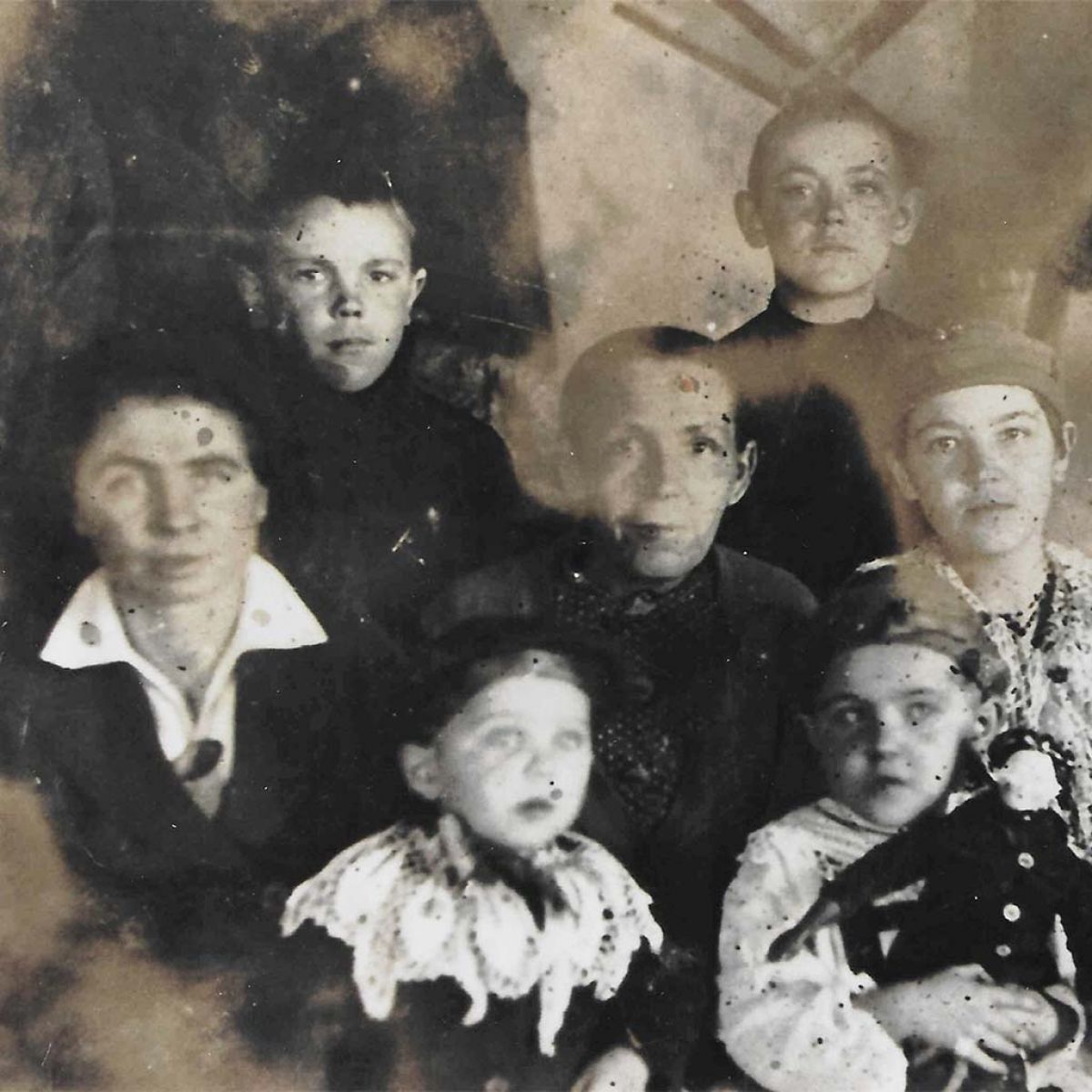 Das Foto zeigt Maria Hölzer (Mitte) mit ihren minderjährigen Kindern 1943 in der Verbannung in Katenis. Von links oben: Sohn Eduard, Sohn Arnhold, Tochter Erna, Tochter Emma (meine Mutter), Walter und Maria (Familie des Sohnes Heinrich).